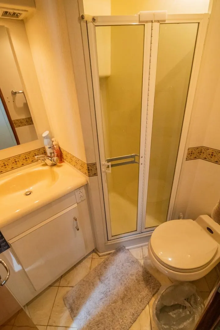 Slide: The Image of Bathroom interior of 1999 Viking 58 Enclosed Bridge yacht, featuring shower, sink, and toilet. - 20