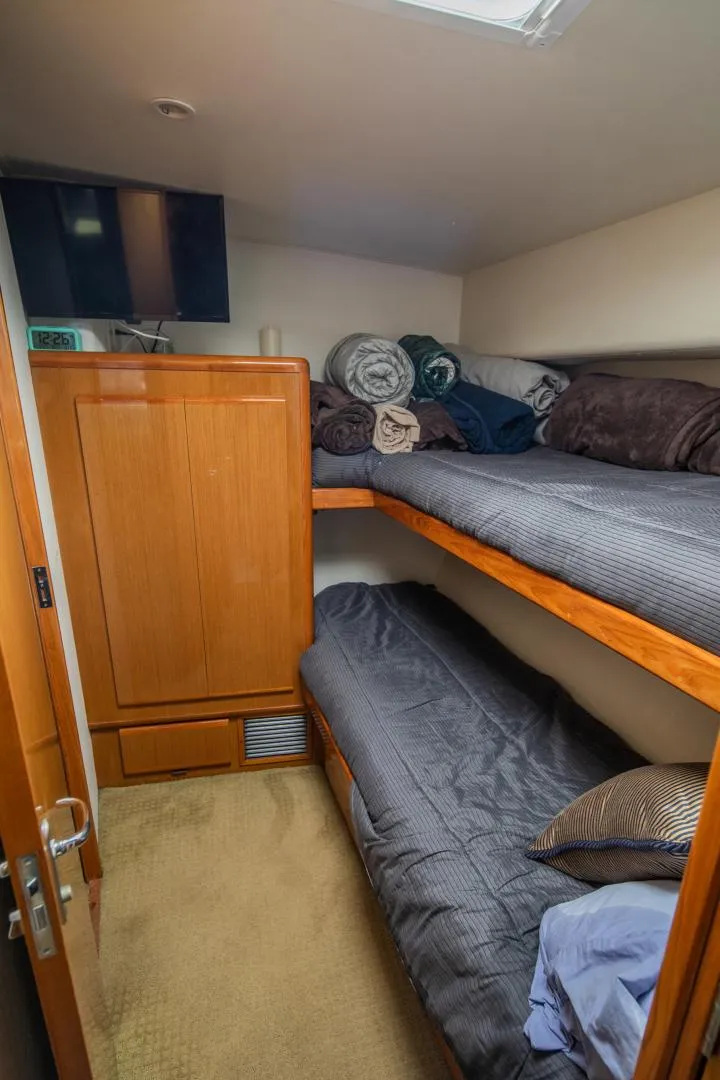 Slide: The Image of Cozy cabin with bunk beds in a 1999 Viking 58 Enclosed Bridge yacht. - 22