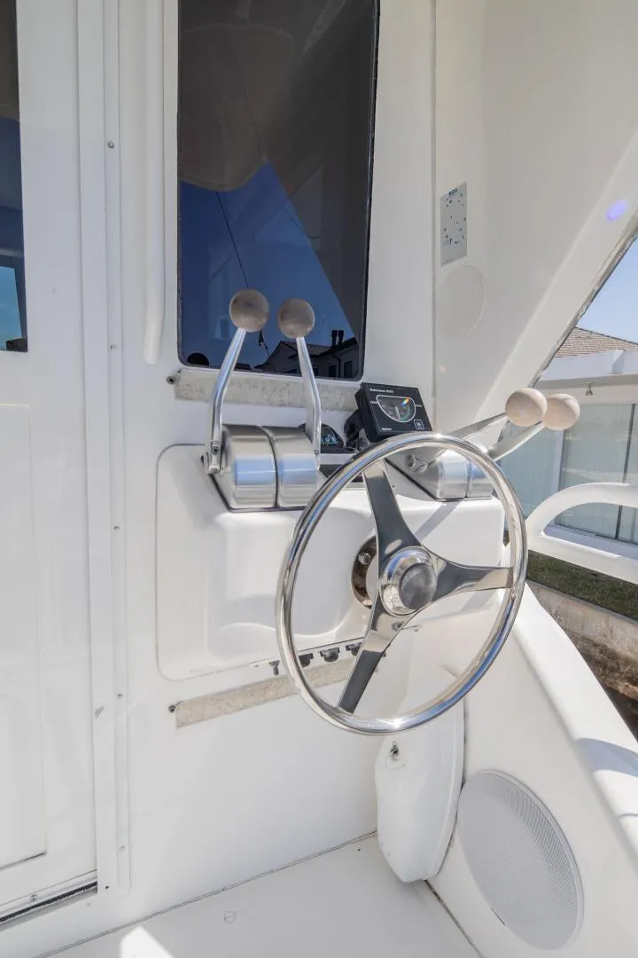 Slide: The Image of 1999 Viking 58 Enclosed Bridge yacht helm with steering wheel and controls. - 28