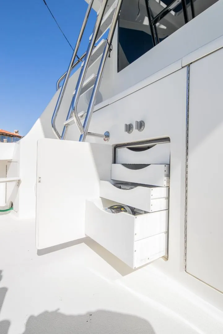 Slide: The Image of 1999 Viking 58 Enclosed Bridge yacht with open storage drawers and ladder. - 30