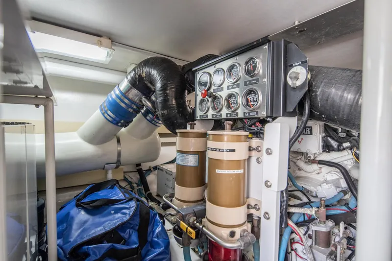 Slide: The Image of Engine room of 1999 Viking 58 Enclosed Bridge with gauges and filters visible. - 42