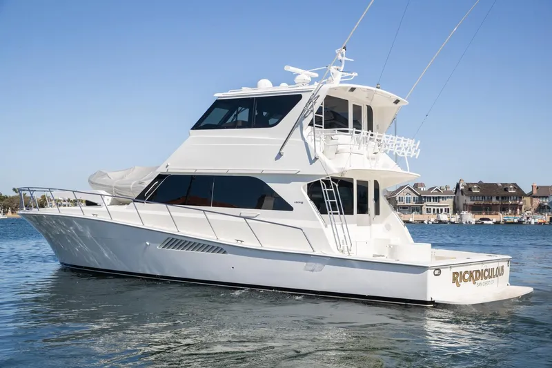 Slide: The Image of 1999 Viking 58 Enclosed Bridge yacht on calm water, clear sky background. - 44