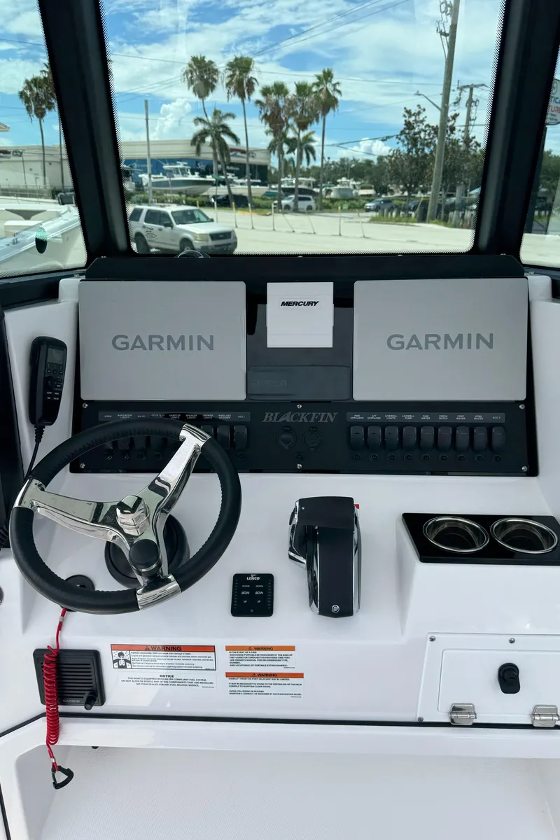 Slide: The Image of 2025 Blackfin 252 CC boat dashboard with Garmin displays and Mercury controls. - 10