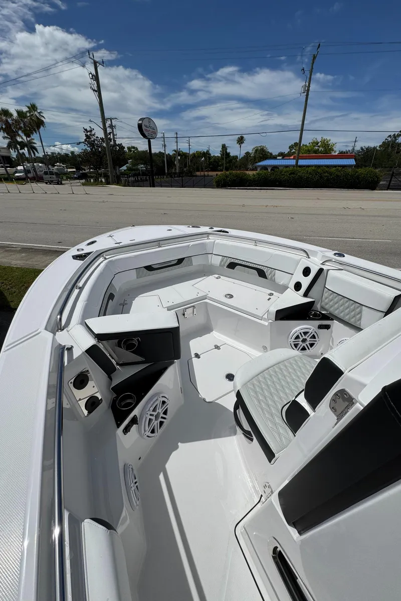 Slide: The Image of 2025 Blackfin 252 CC boat interior with seating and speakers under a clear sky. - 11