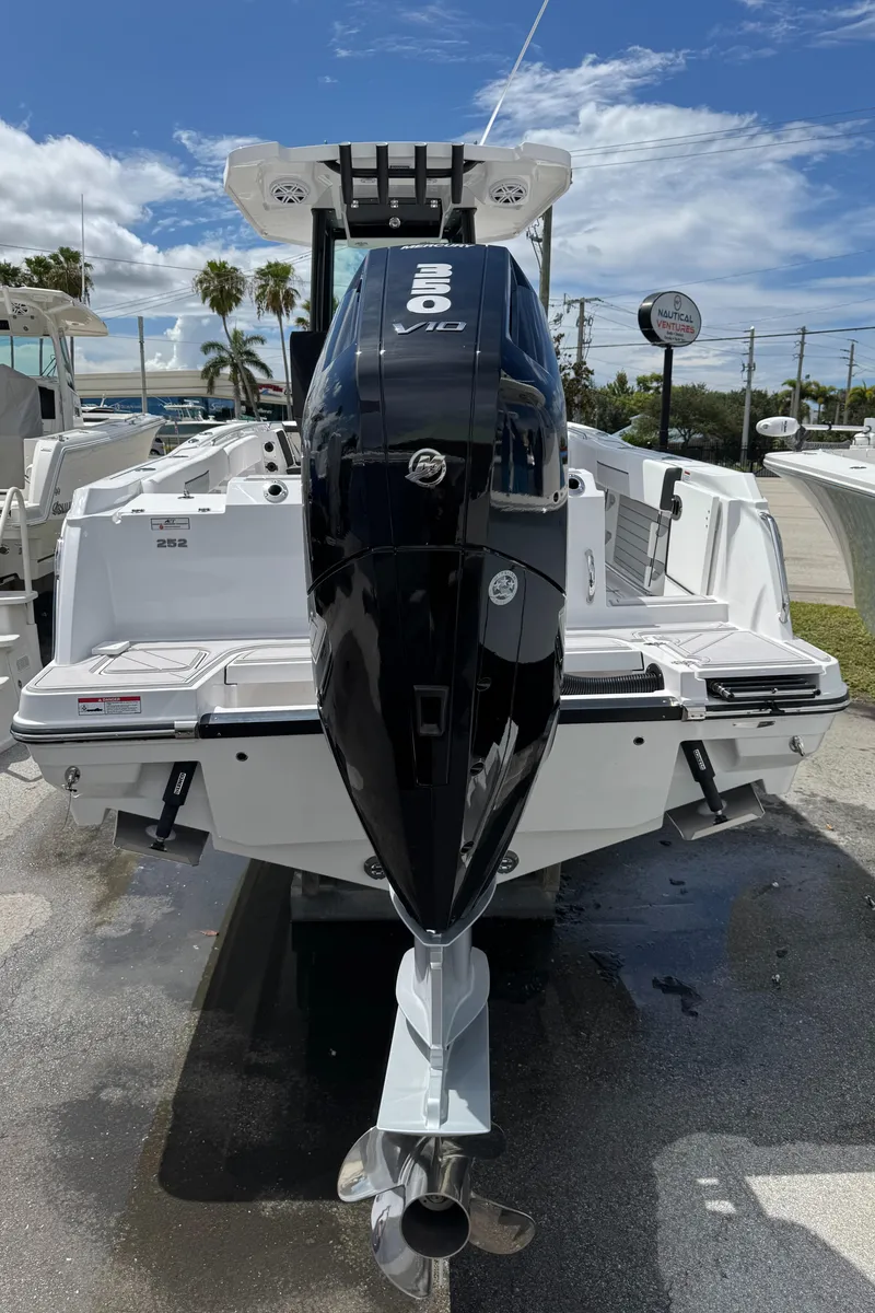 Slide: The Image of 2025 Blackfin 252 CC boat with powerful outboard motor, docked under clear skies. - 3