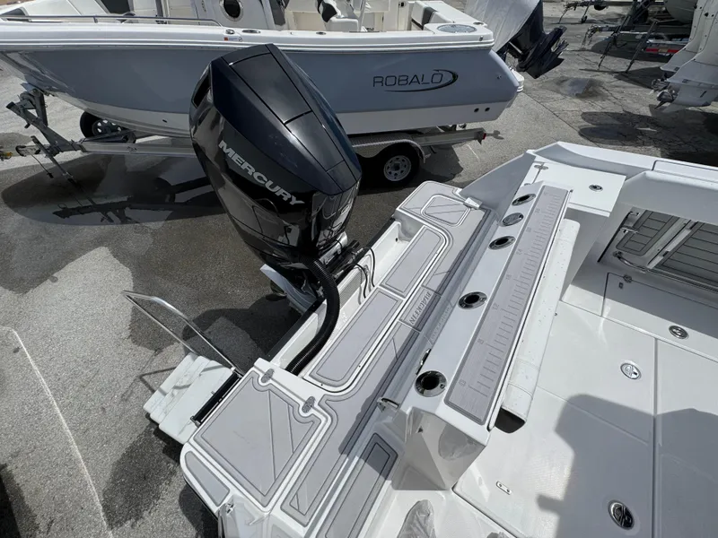 Slide: The Image of 2025 Blackfin 252 CC boat with Mercury engine, docked beside a Robalo boat. - 4