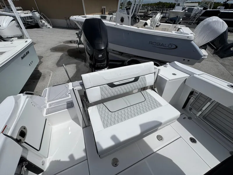 Slide: The Image of 2025 Blackfin 252 CC boat interior with seating and outboard motor in a marina setting. - 5