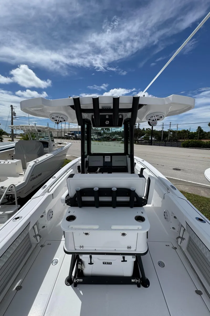 Slide: The Image of 2025 Blackfin 252 CC boat interior with seating and console under a clear blue sky. - 6