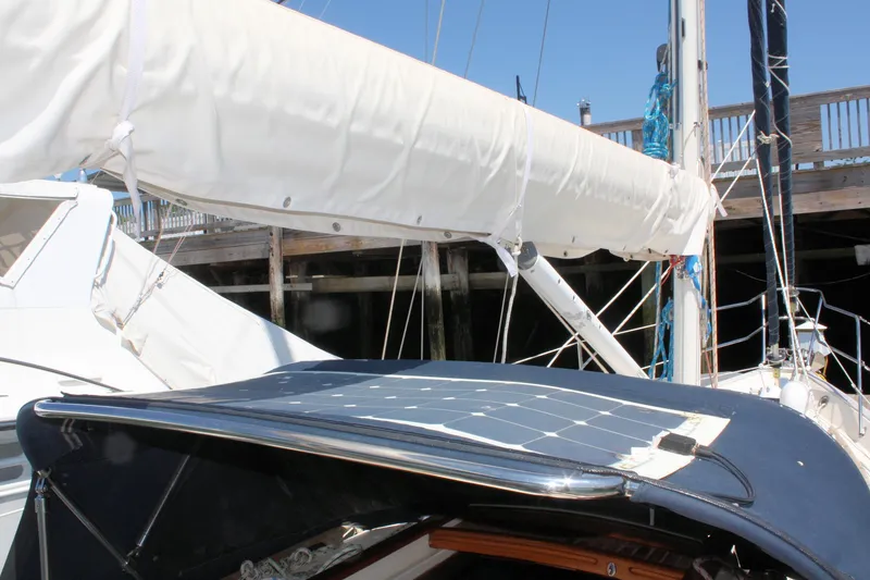 Slide: The Image of Sailboat Pacific Seacraft 31, 2004 model, with solar panel and covered boom, docked at marina. - 11
