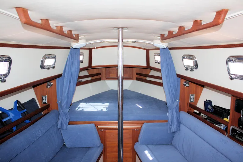 Slide: The Image of Interior of 2004 Pacific Seacraft 31 sailboat with blue upholstery and wooden accents. - 24