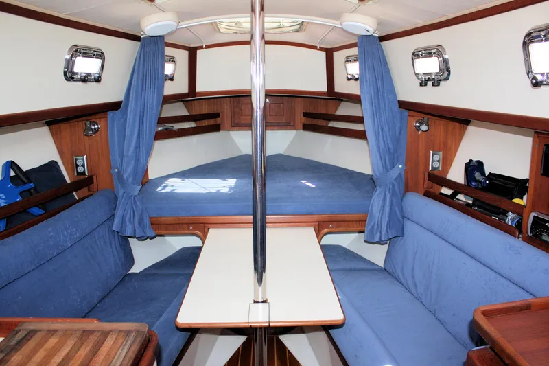 Slide: The Image of Interior of 2004 Pacific Seacraft 31 sailboat with blue upholstery and wooden accents. - 26