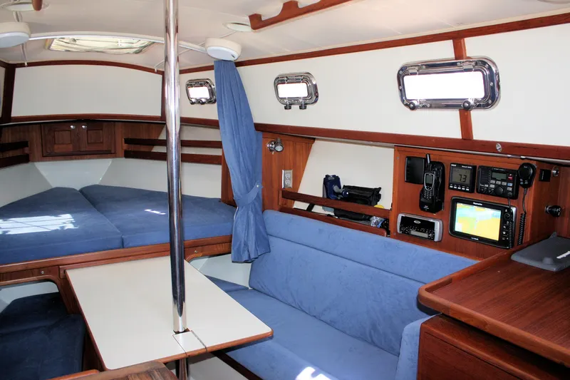 Slide: The Image of Interior of 2004 Pacific Seacraft 31 sailboat with blue seating and navigation equipment. - 27
