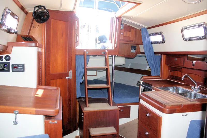 Slide: The Image of Interior of 2004 Pacific Seacraft 31 sailboat with wood finish and compact kitchen area. - 30