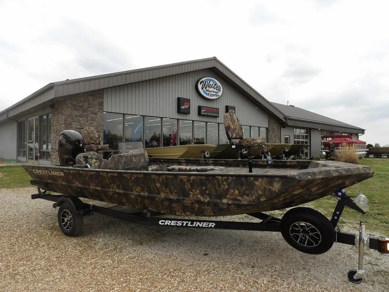 The Image of 2025 Crestliner 2070 Retriever SCHD boat with camouflage design outside marine center. - 1