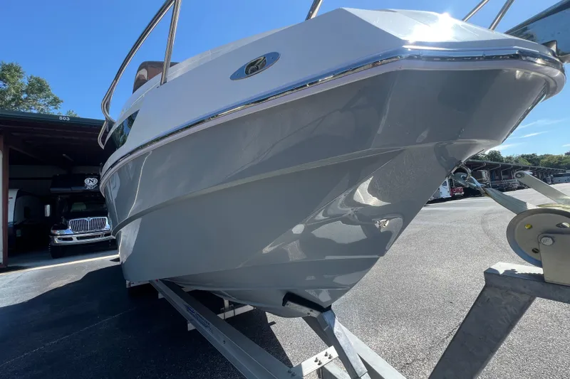 Slide: The Image of 2024 NX Boats 290 Exclusive on trailer, sleek design under bright blue sky. - 11
