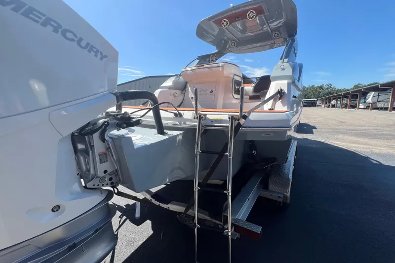 Slide: The Image of 2024 NX Boats 290 Exclusive with Mercury engine, featuring a swim ladder and spacious deck. - 14