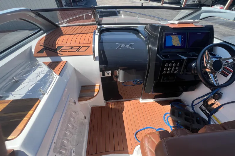 Slide: The Image of 2024 NX Boats 290 Exclusive cockpit with modern controls and wood accents. - 21