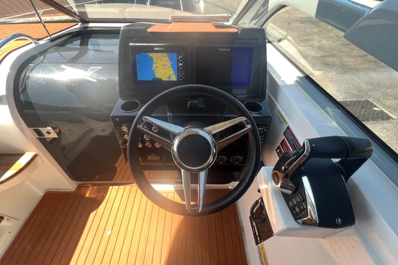 Slide: The Image of 2024 NX Boats 290 Exclusive dashboard with steering wheel and navigation screens. - 24