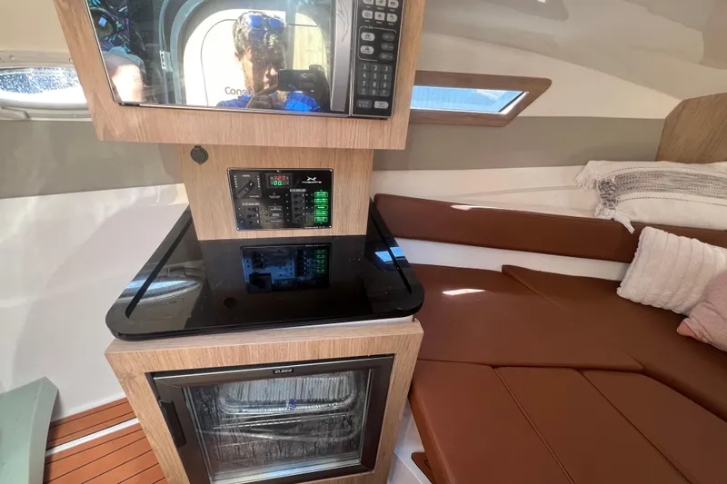 Slide: The Image of 2024 NX Boats 290 Exclusive interior with modern kitchen and cozy seating area. - 28