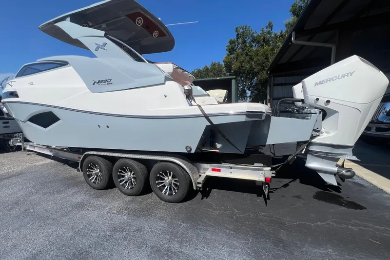 Slide: The Image of 2024 NX Boats 290 Exclusive on trailer, featuring sleek design and powerful Mercury outboard engine. - 3
