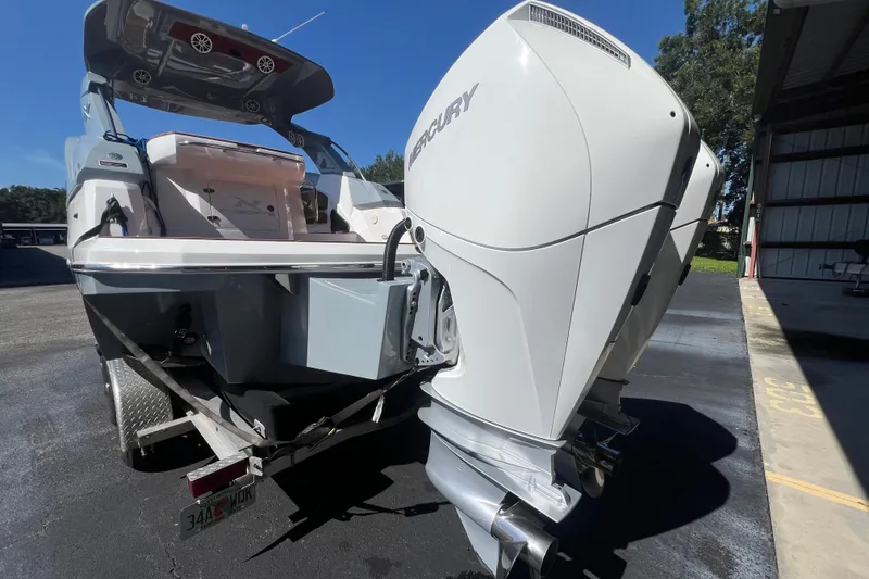 Slide: The Image of 2024 NX Boats 290 Exclusive with Mercury outboard engine on a trailer. - 4