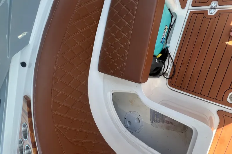 Slide: The Image of 2024 NX Boats 290 Exclusive interior with brown leather seating and wood flooring. - 42