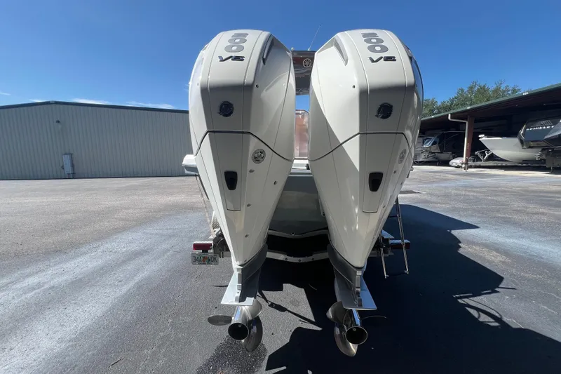 Slide: The Image of 2024 NX Boats 290 Exclusive with dual outboard engines in a marina setting. - 5
