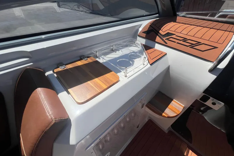 Slide: The Image of 2024 NX Boats 290 Exclusive interior with wooden accents and cup holders. - 54