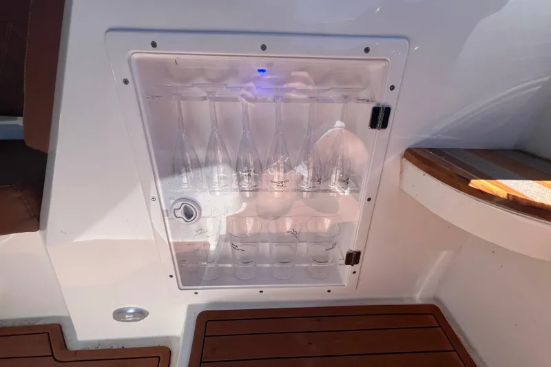 Slide: The Image of 2024 NX Boats 290 Exclusive glass storage compartment with elegant design and wooden flooring. - 59