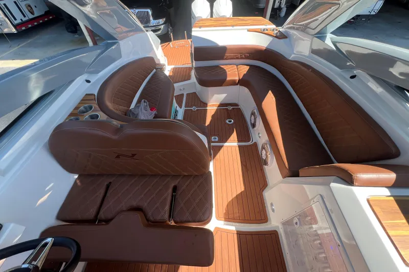 Slide: The Image of 2024 NX Boats 290 Exclusive interior with luxurious brown leather seating and wood accents. - 66