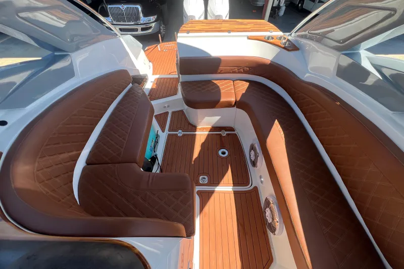 Slide: The Image of 2024 NX Boats 290 Exclusive interior with luxurious brown leather seating and wood flooring. - 67