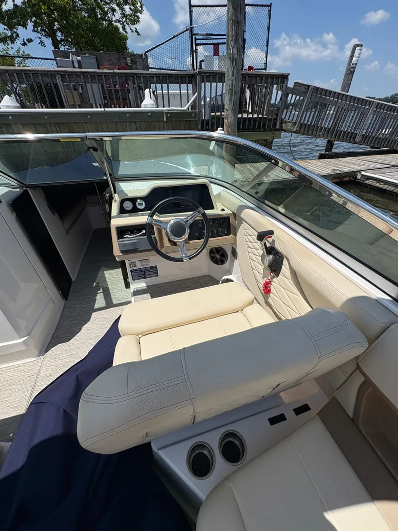 Slide: The Image of 2019 Regal 26 OBX boat interior with steering wheel and beige seating. - 12