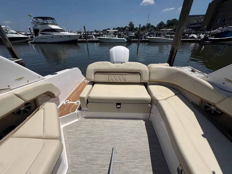 Slide: The Image of 2019 Regal 26 OBX boat interior with beige seating at marina. - 2