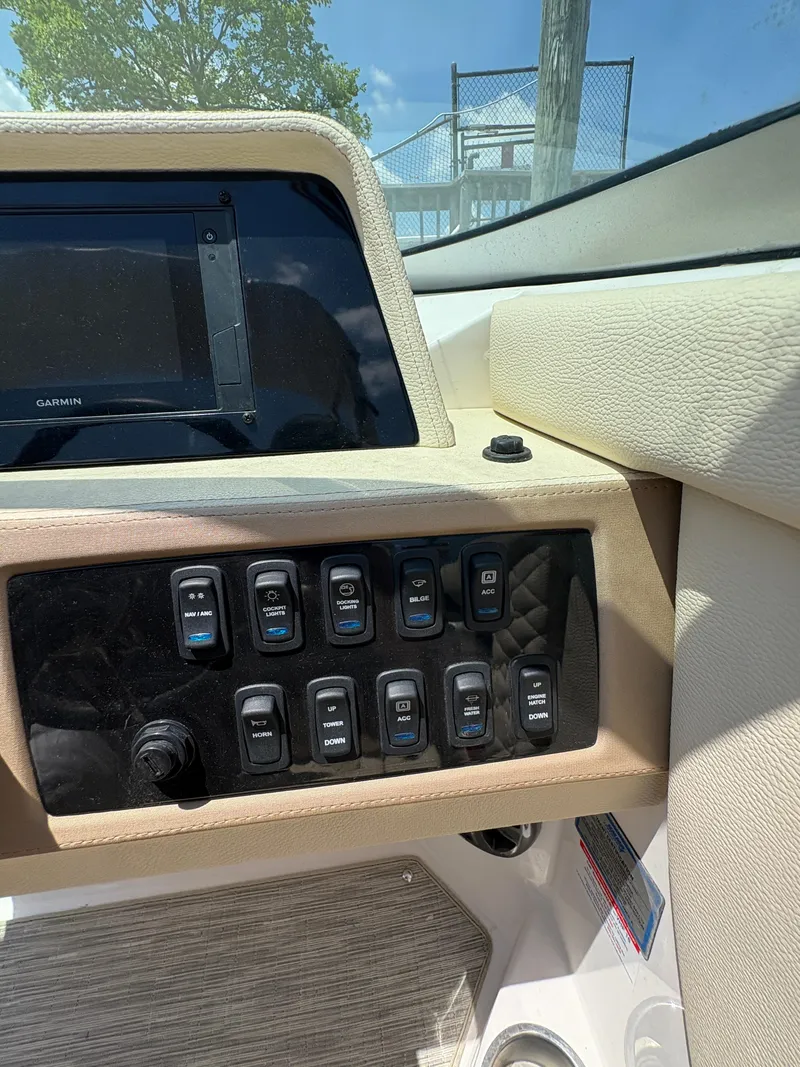 Slide: The Image of Control panel of a 2019 Regal 26 OBX boat with switches and a Garmin display. - 7