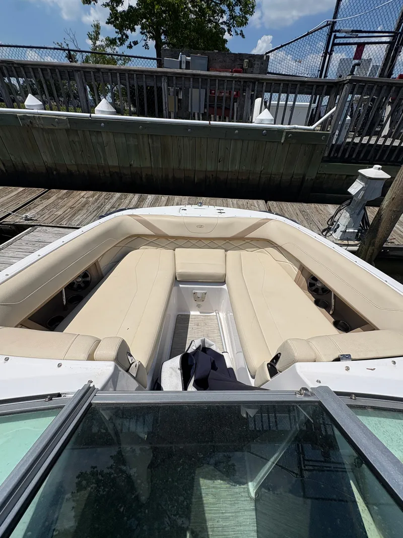 Slide: The Image of 2019 Regal 26 OBX boat with beige seating docked at a marina. - 8