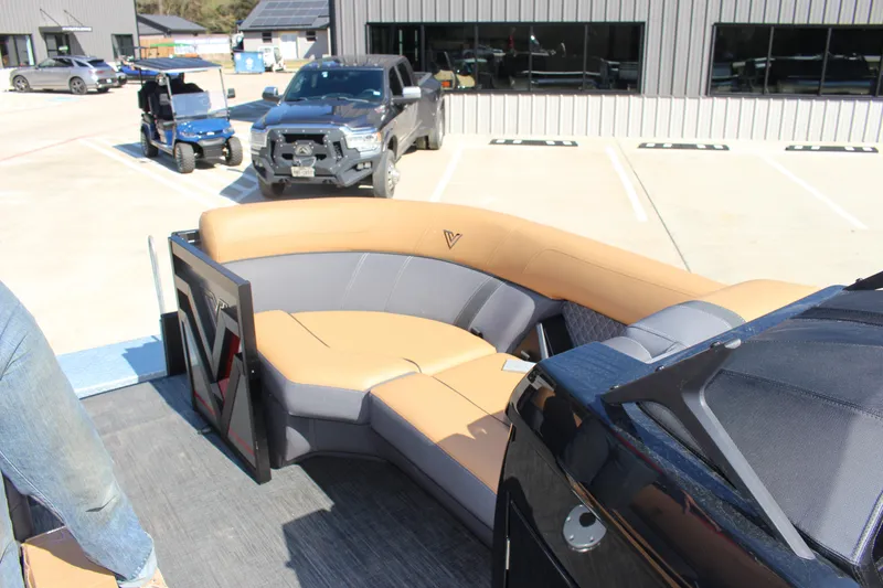 Slide: The Image of 2025 Viaggio Lago Z22S CC boat interior with tan and gray seating in a parking lot. - 7