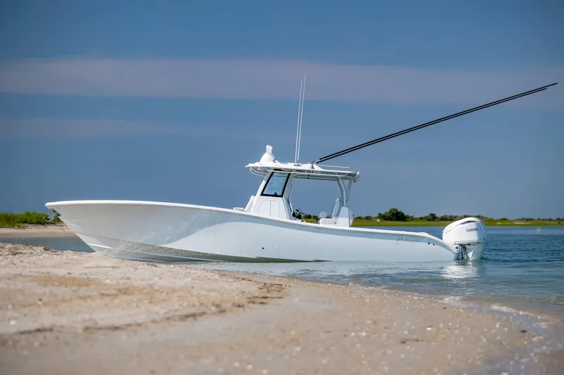 Slide: The Image of 2026 Yellowfin 36 Offshore boat on sandy shore with clear blue sky. - 12