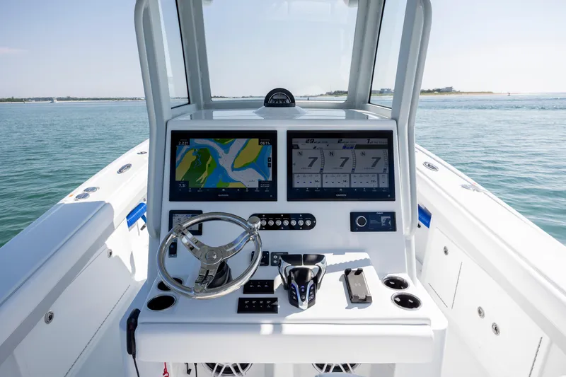 Slide: The Image of 2026 Yellowfin 36 Offshore boat dashboard with navigation screens and steering wheel. - 19