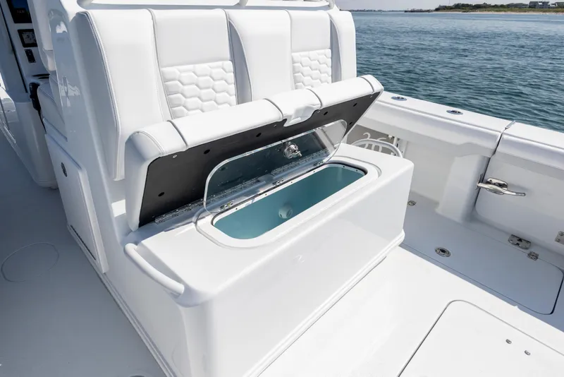 Slide: The Image of 2026 Yellowfin 36 Offshore boat with open storage compartment, white seating, and ocean backdrop. - 23