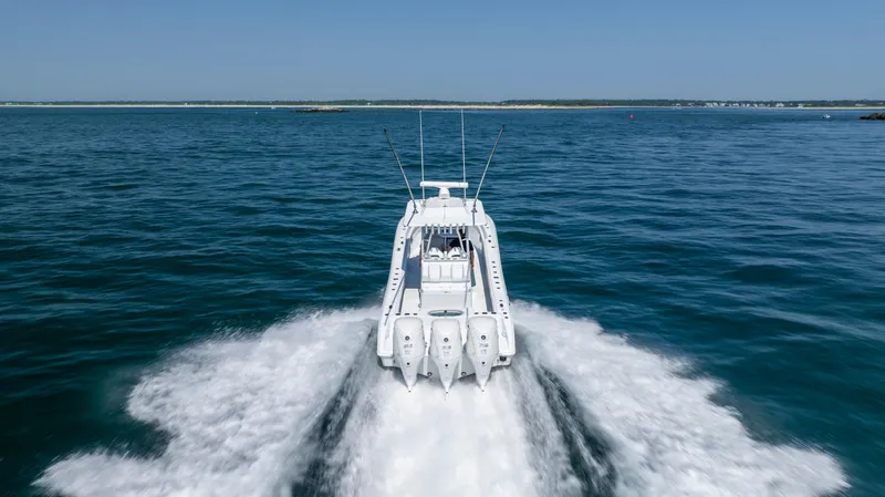 Slide: The Image of 2026 Yellowfin 36 Offshore boat cruising on open water, rear view. - 34