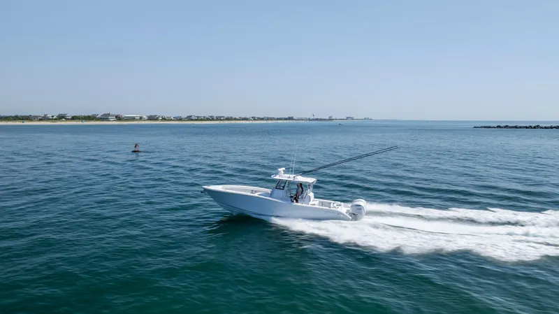 Slide: The Image of 2026 Yellowfin 36 Offshore boat cruising on open water, clear sky, distant shoreline. - 36