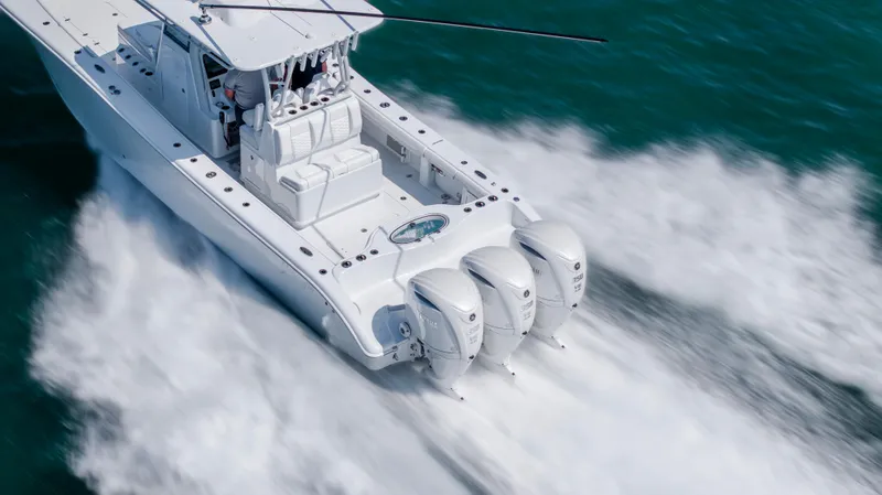 Slide: The Image of 2026 Yellowfin 36 Offshore boat speeding on water with triple outboard engines. - 37