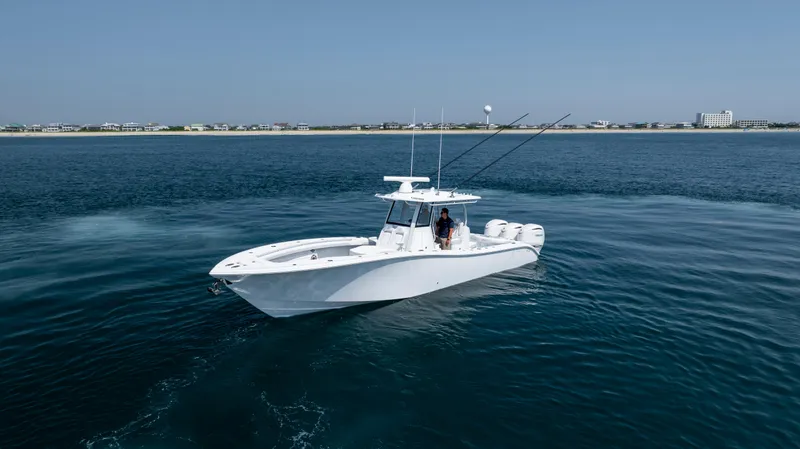 Slide: The Image of 2026 Yellowfin 36 Offshore boat cruising on calm blue waters near the coastline. - 47