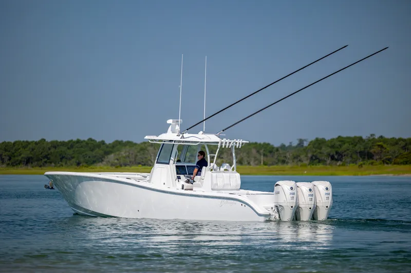 Slide: The Image of 2026 Yellowfin 36 Offshore boat cruising on calm water with triple outboard engines. - 7