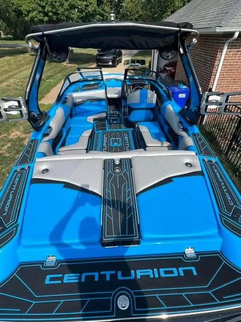 Slide: The Image of 2022 Centurion Fi23 boat with blue and gray interior, parked outdoors. - 3