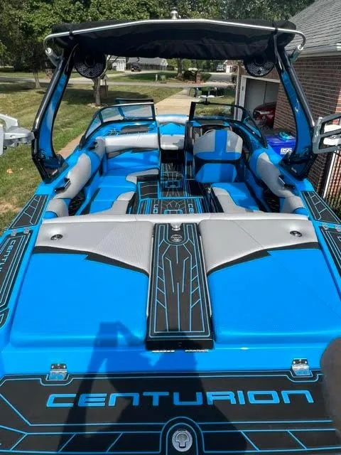 Slide: The Image of 2022 Centurion Fi23 boat with blue and gray interior, parked outdoors. - 5