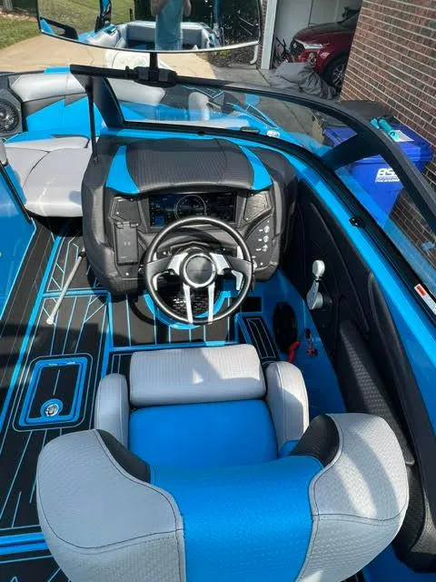 Slide: The Image of 2022 Centurion Fi23 boat interior with blue and gray seating, modern dashboard, and steering wheel. - 6