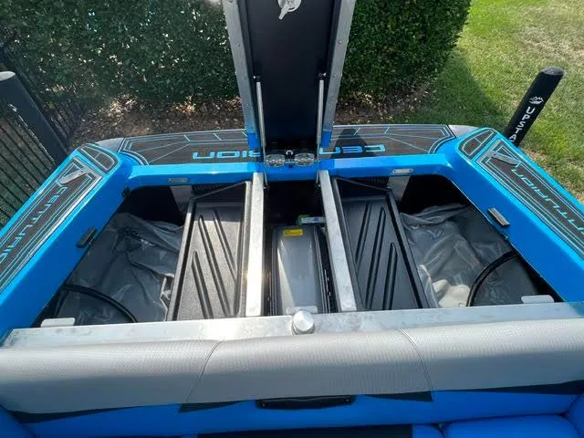 Slide: The Image of 2022 Centurion Fi23 boat interior with open storage compartments, blue and gray design. - 9