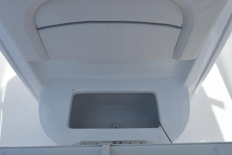 Slide: The Image of 2026 Sea Hunt Ultra 245 SE boat storage compartment with cushioned seating. - 16