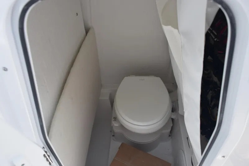 Slide: The Image of Compact marine toilet inside 2026 Sea Hunt Ultra 245 SE boat cabin. - 17